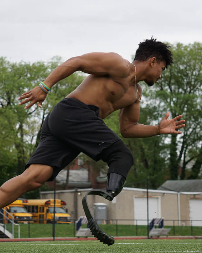 Image of young man wearing prosthetic cleat while running