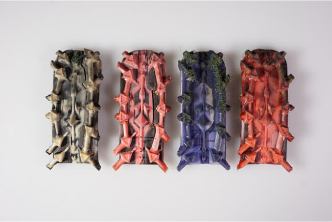 Image of four prosthetic cleats of different colors in a row