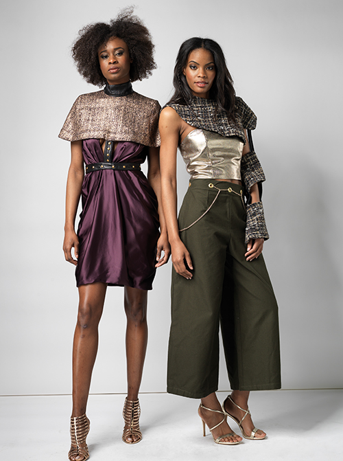 Image of 2 women standing in fashion outfits. One has a dress and the other is in pants